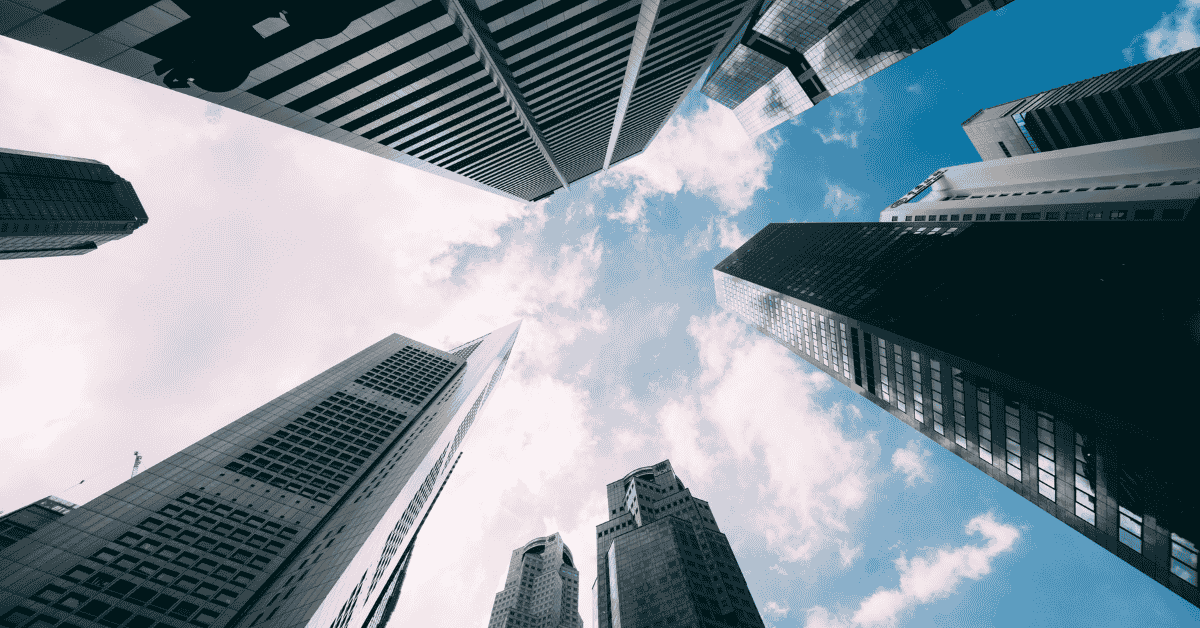 Low-angle view of modern skyscrapers against a blue sky with clouds, symbolizing business, finance, banks and corporate success.