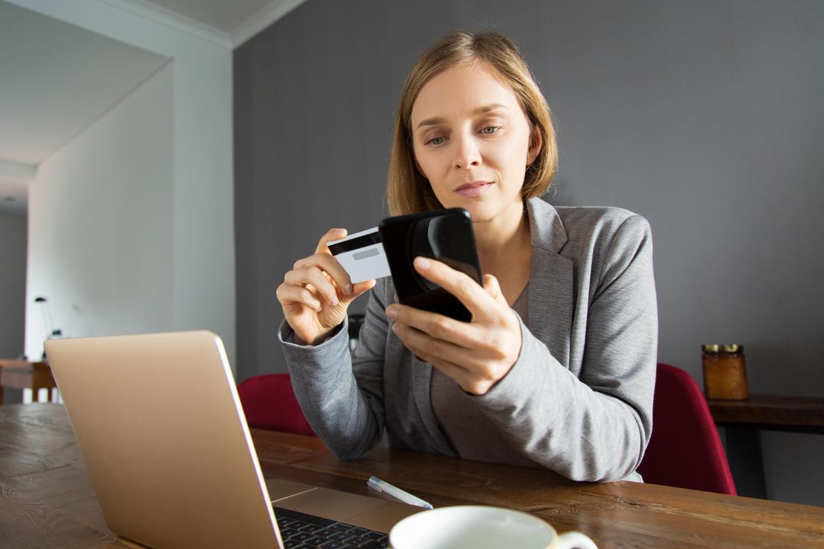 Woman making an online payment with a credit card on smartphone at home